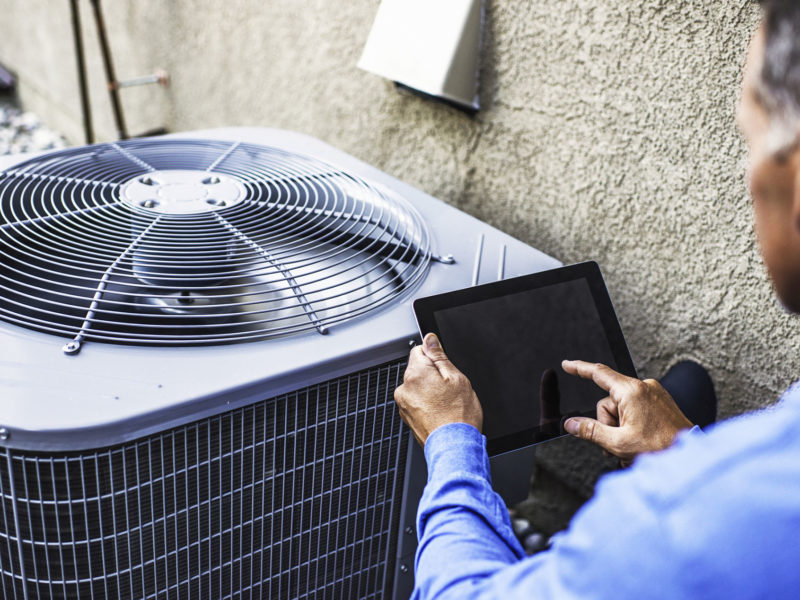 HVAC technician doing air conditioning maintenance