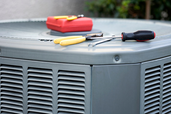 Tools on top of an outside HVAC unit