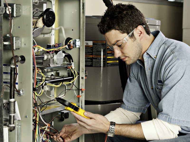 HVAC technician testing a home furnace